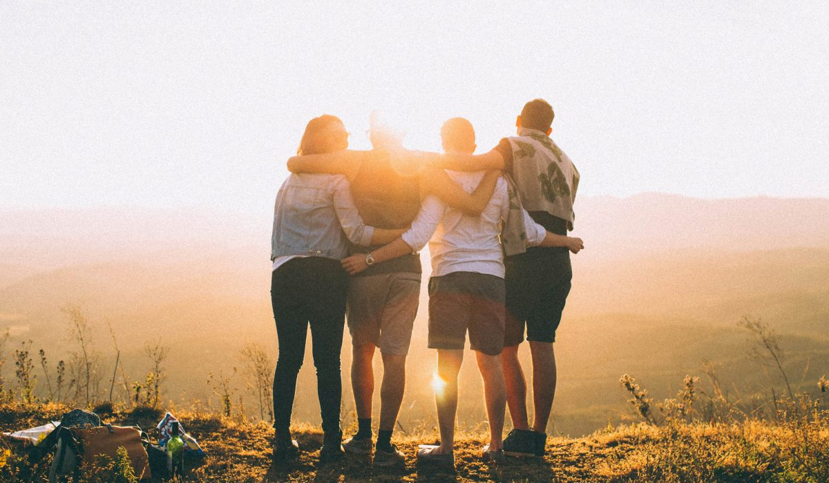 Image of four friends, who're having a great time together at sunset, their friendship is strong.